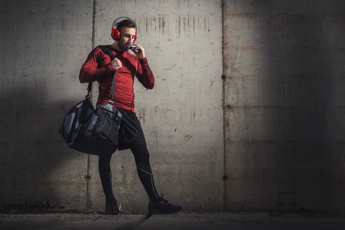 Man in gym clothes eating a bar
