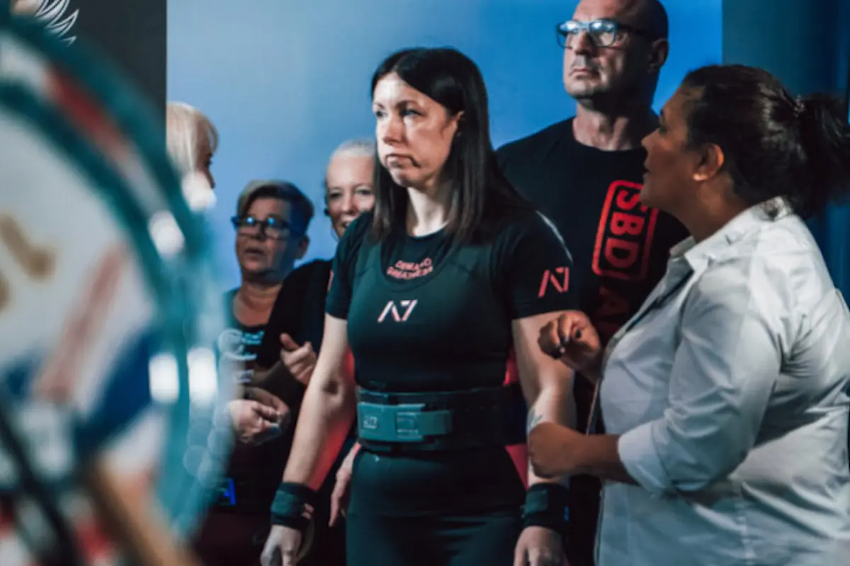 Older women lifters at competition with coach