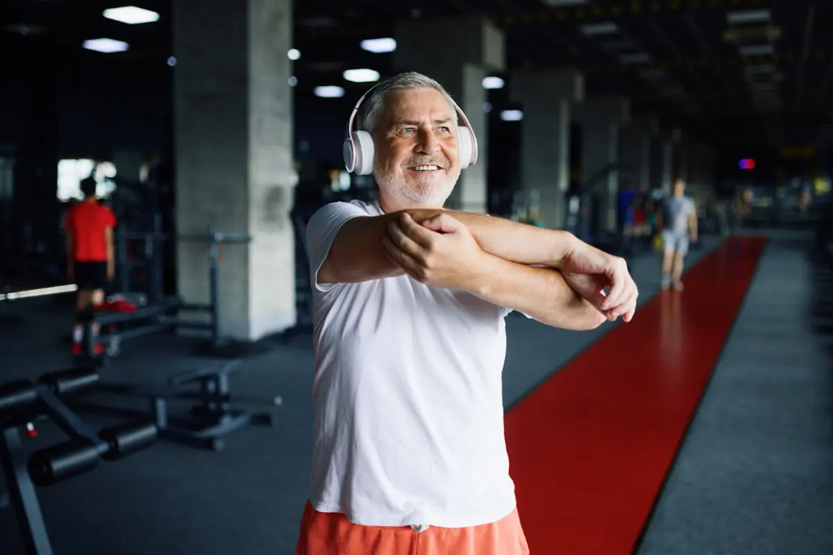 Older man stretching in the gym