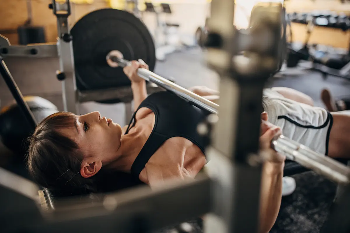 Close-up from the side of woman benching