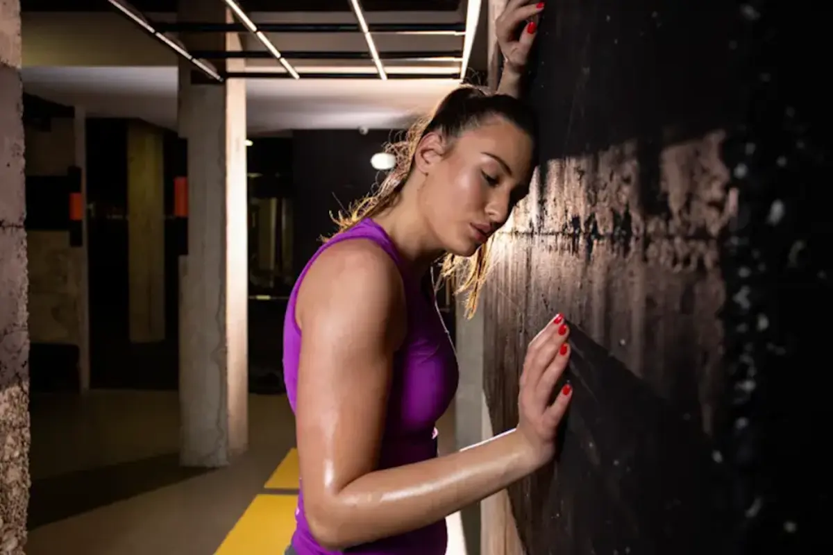 Female lifter leaning against the gym wall