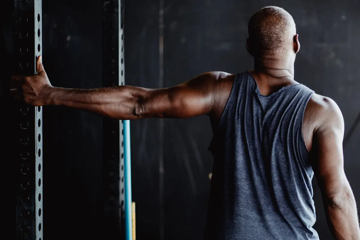 Man stretching his shoulder in the gym