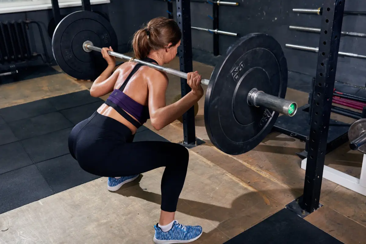Woman halfway down a barbell back squat