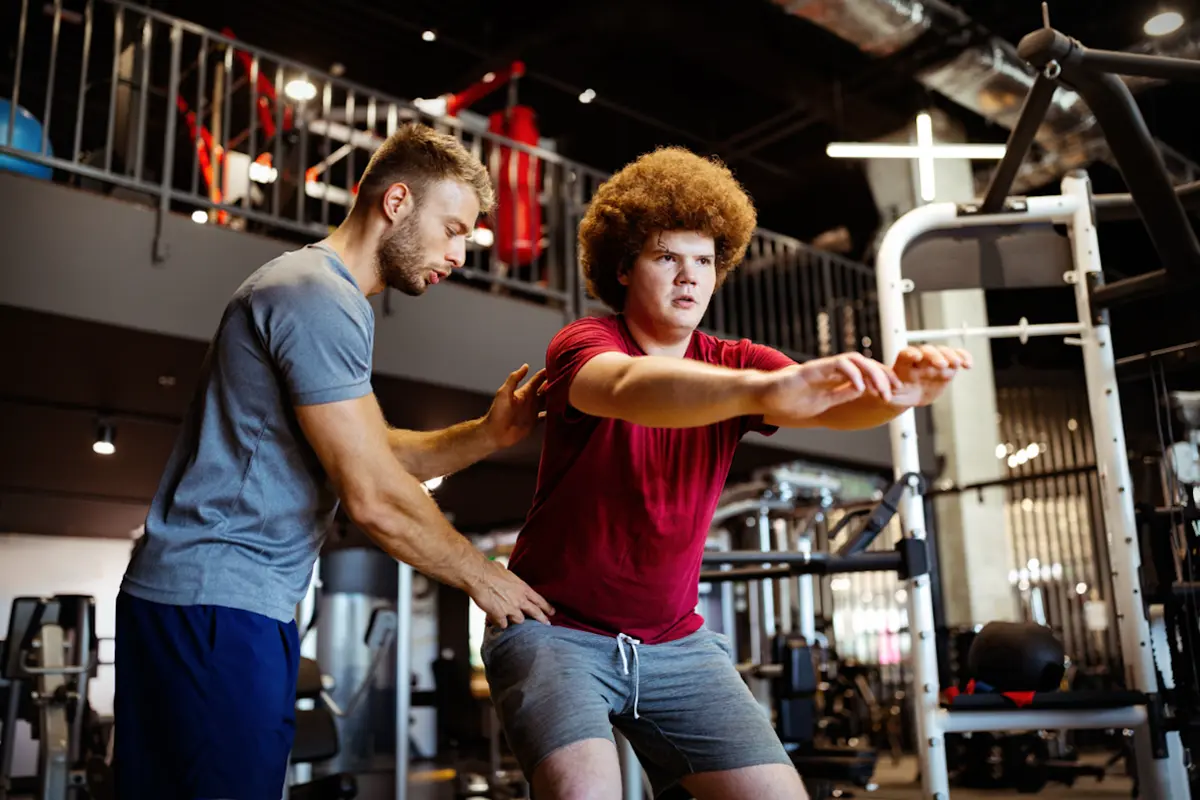 Boy being coached in squat technique