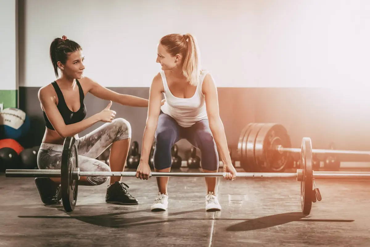 Woman coach teaching woman how to deadlift